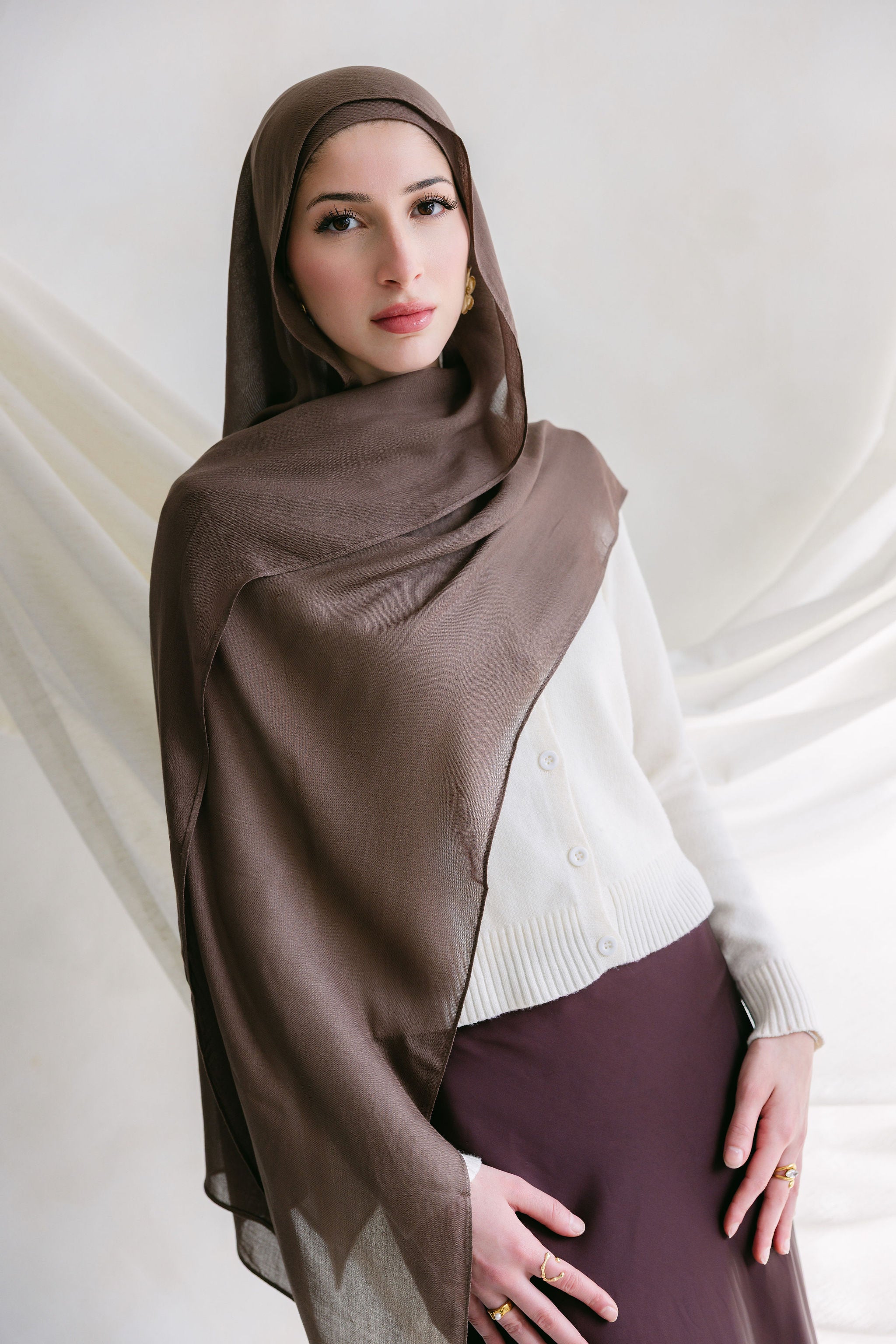 Deep taupe fabric from Threads by Farah displayed in a branding photoshoot, showcasing its texture and rich color.