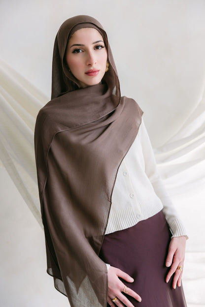 Deep taupe fabric from Threads by Farah displayed in a branding photoshoot, showcasing its texture and rich color.