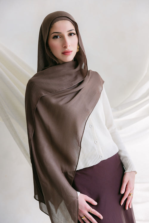 Deep taupe fabric from Threads by Farah displayed in a branding photoshoot, showcasing its texture and rich color.