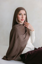 Deep taupe fabric from Threads by Farah, shown in a professional photoshoot with natural lighting and clear fabric texture.
