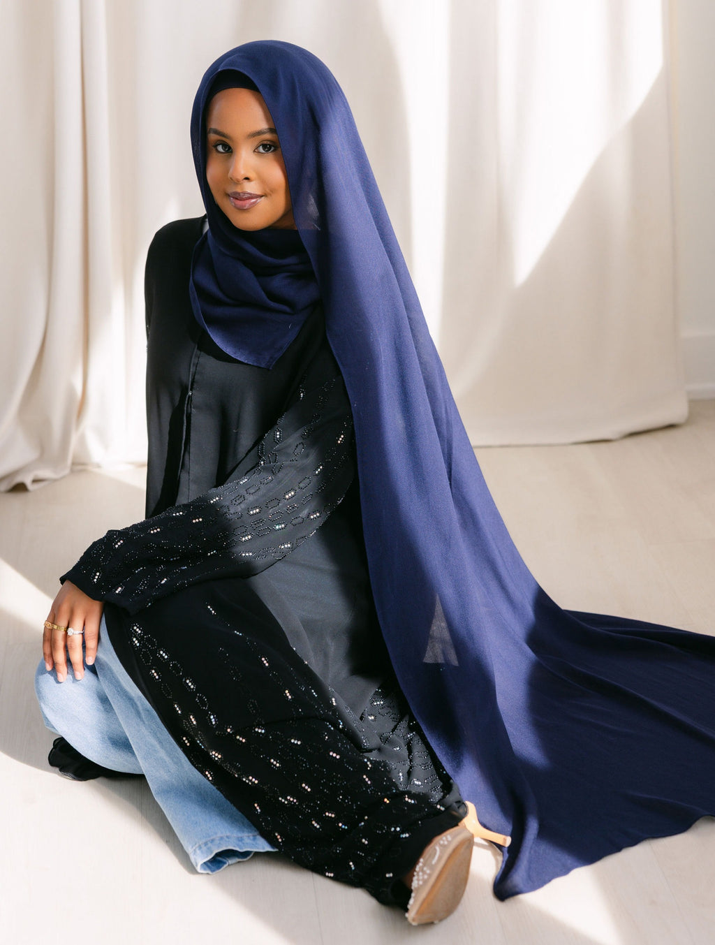 Navy blue fabric from Threads by Farah, shown in a professional branding photoshoot with natural lighting and detailed fabric texture