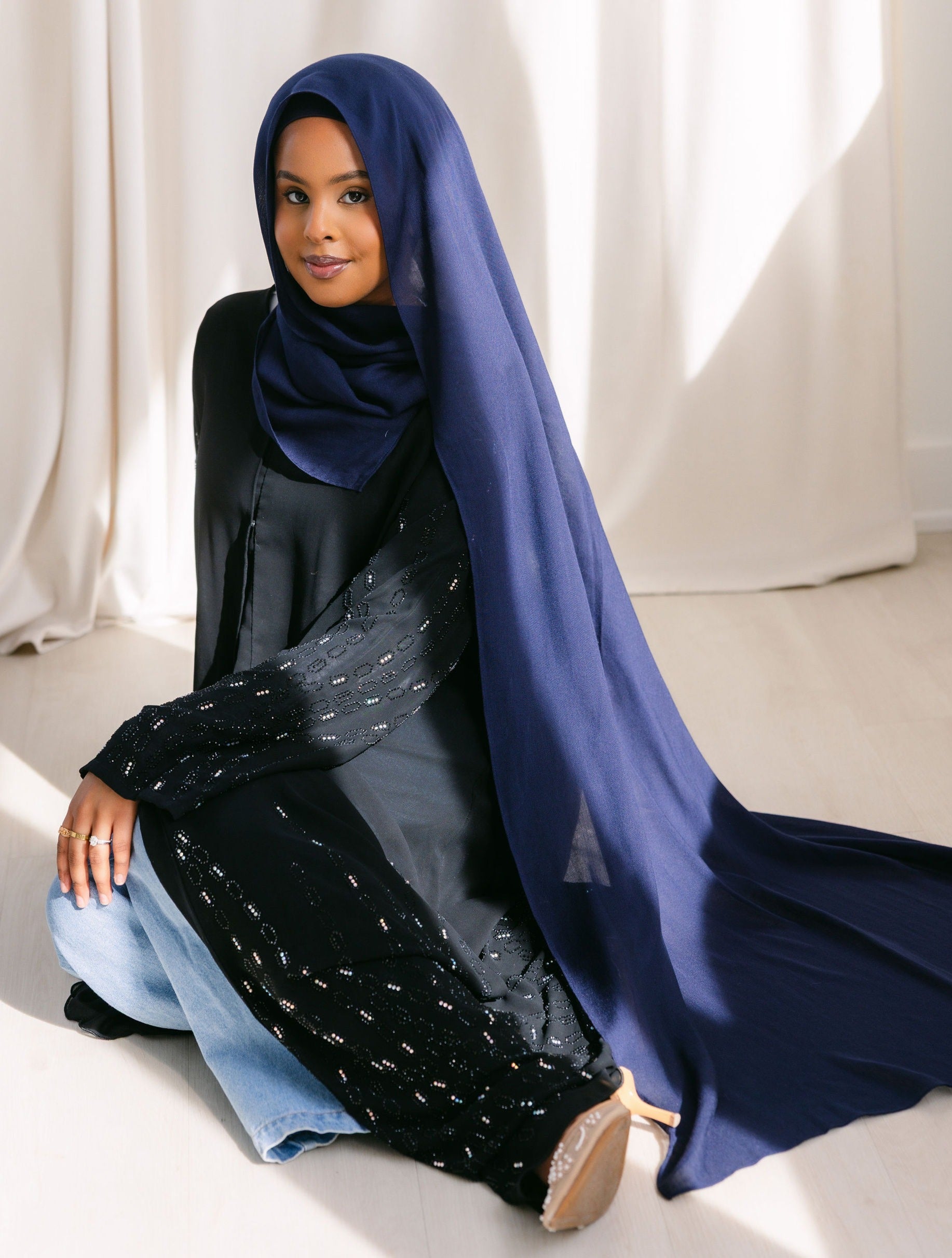 Navy blue fabric from Threads by Farah, shown in a professional branding photoshoot with natural lighting and detailed fabric texture